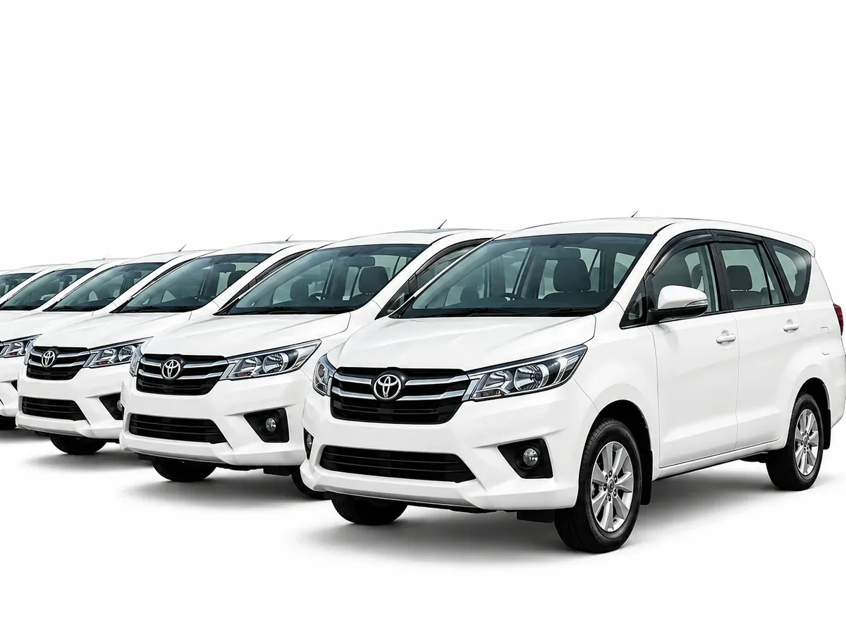 Row of white Toyota Innova cars ready for rental